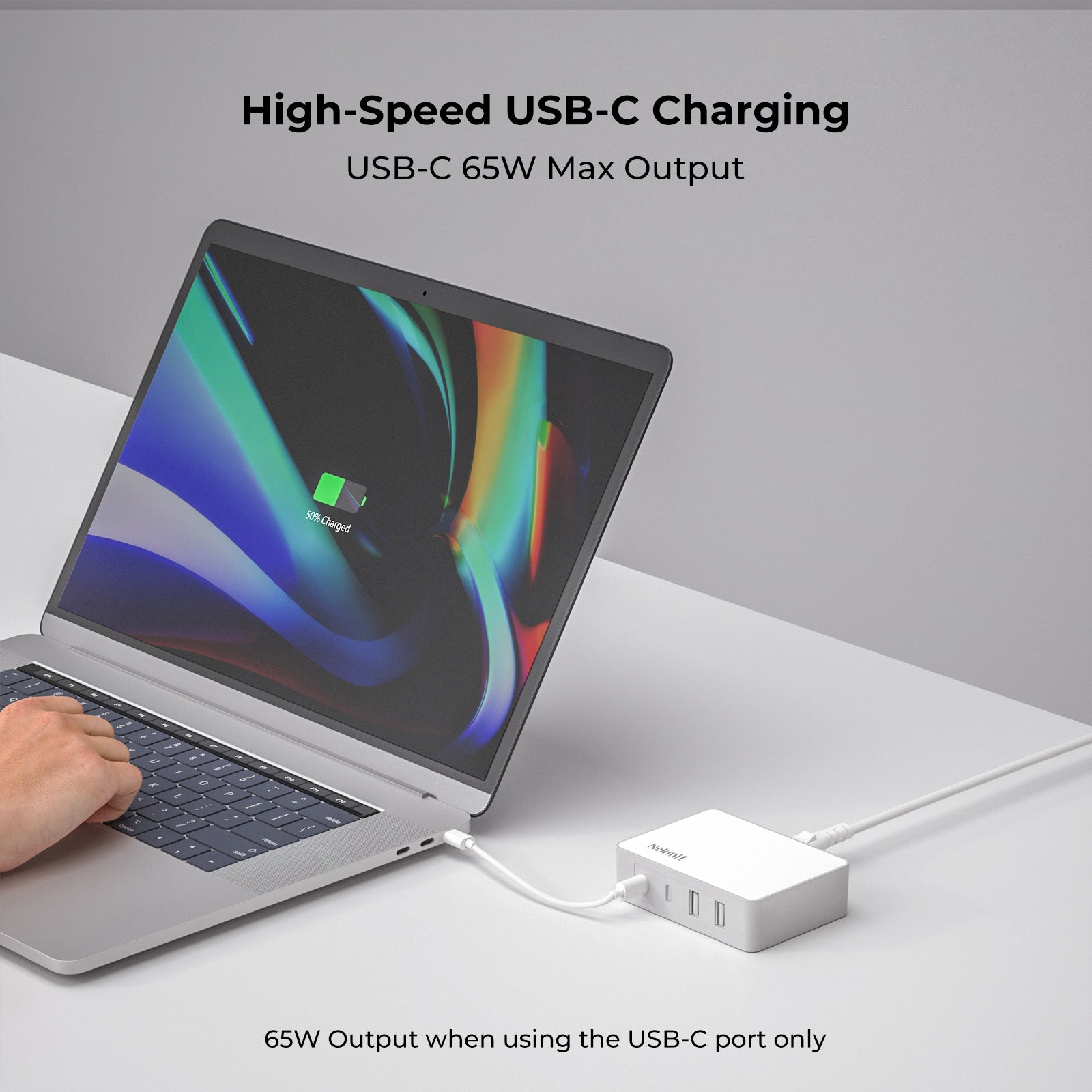 Laptop with USB-C charging adapter on a white surface, highlighting high-speed USB-C charging.