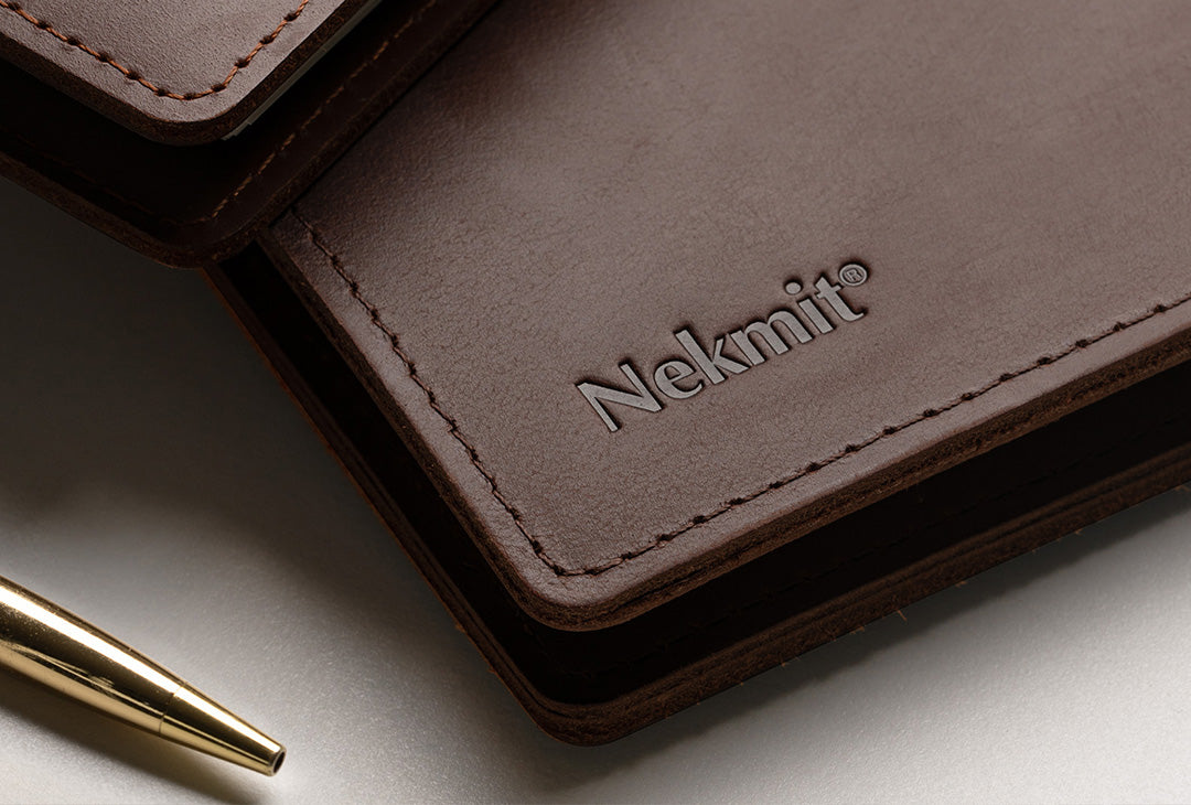 Brown leather wallet with 'Nekmit' branding on a light surface.