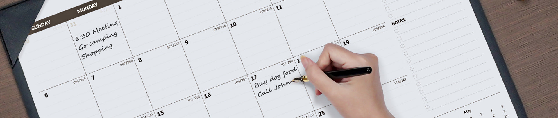 Hand writing on a calendar with a pen