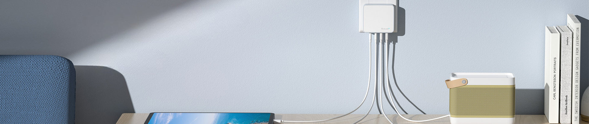 Modern interior with a blue sofa, coffee table, and decorative items against a light gray wall.