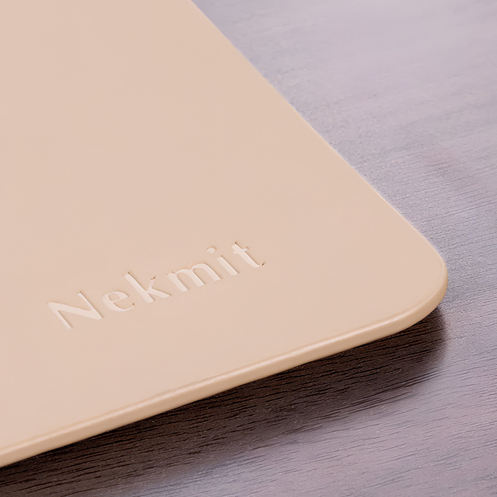 Beige product with 'Nekmit' branding on a wooden surface