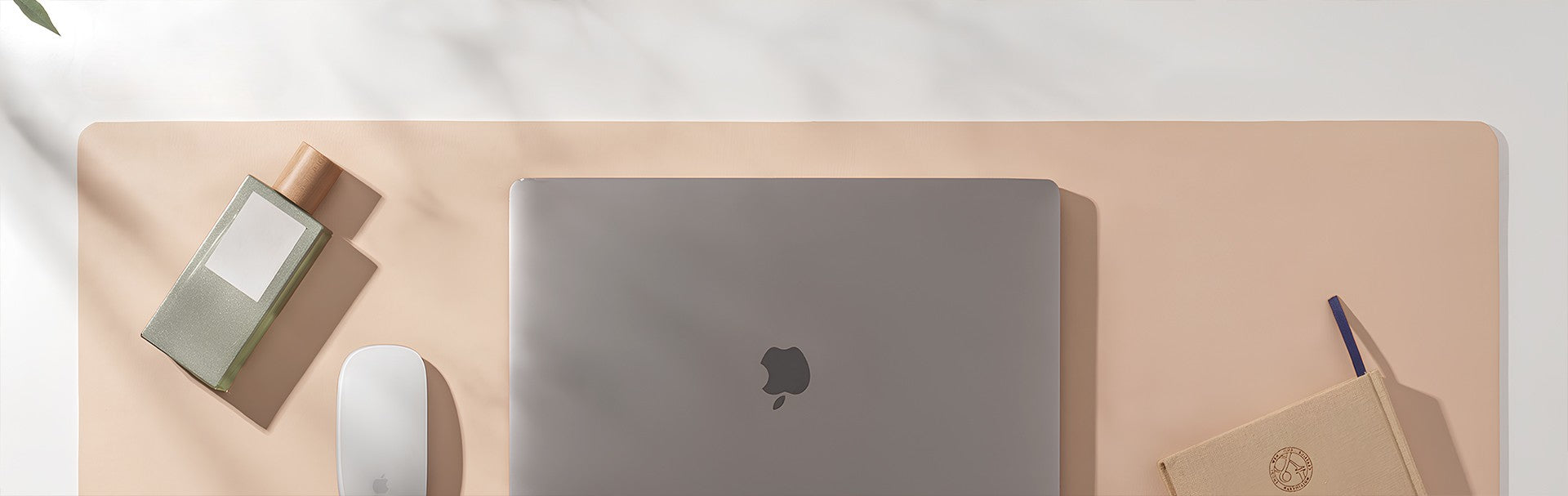 Laptop on a wooden surface with a mouse and notebook