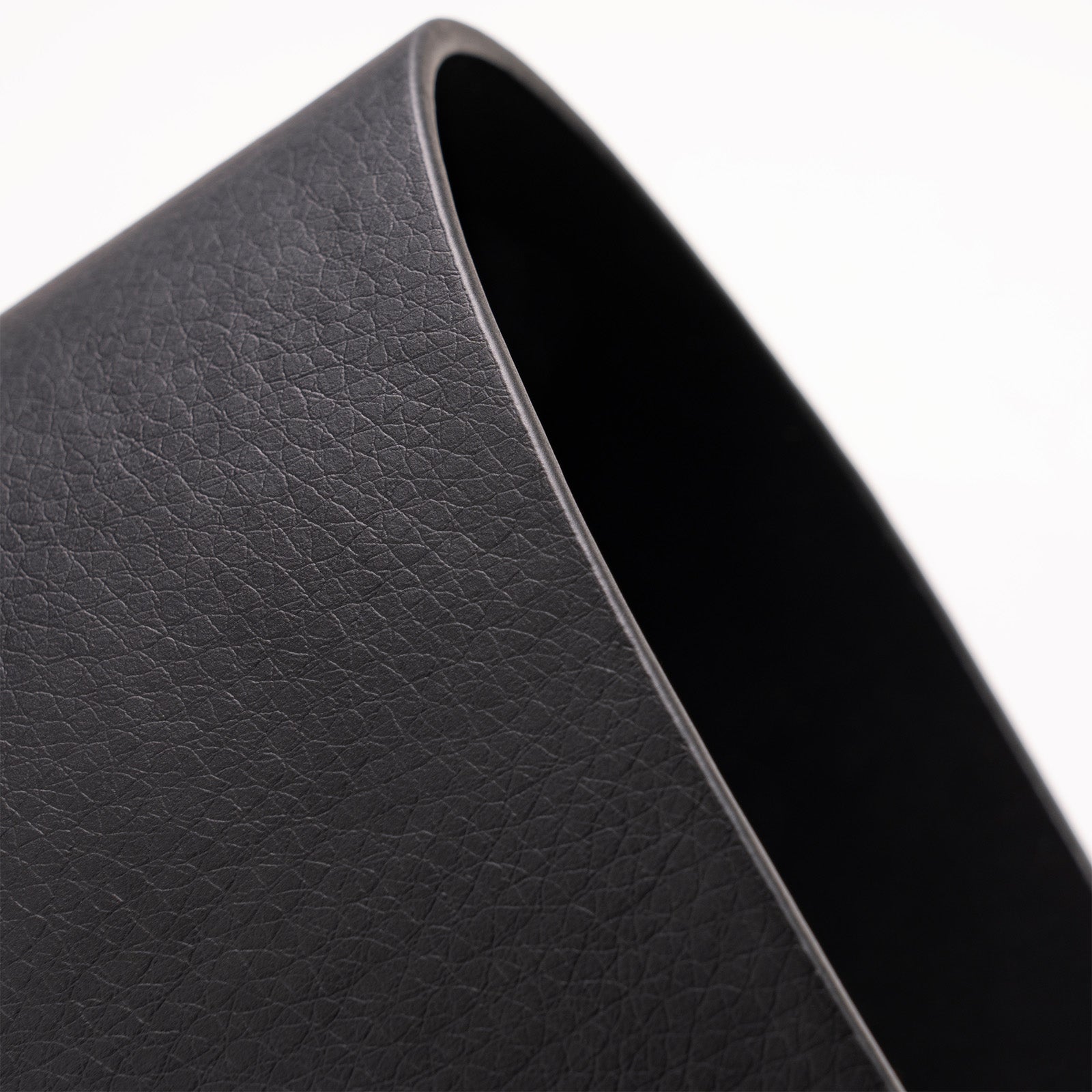 Close-up of a textured black leather product on a white background
