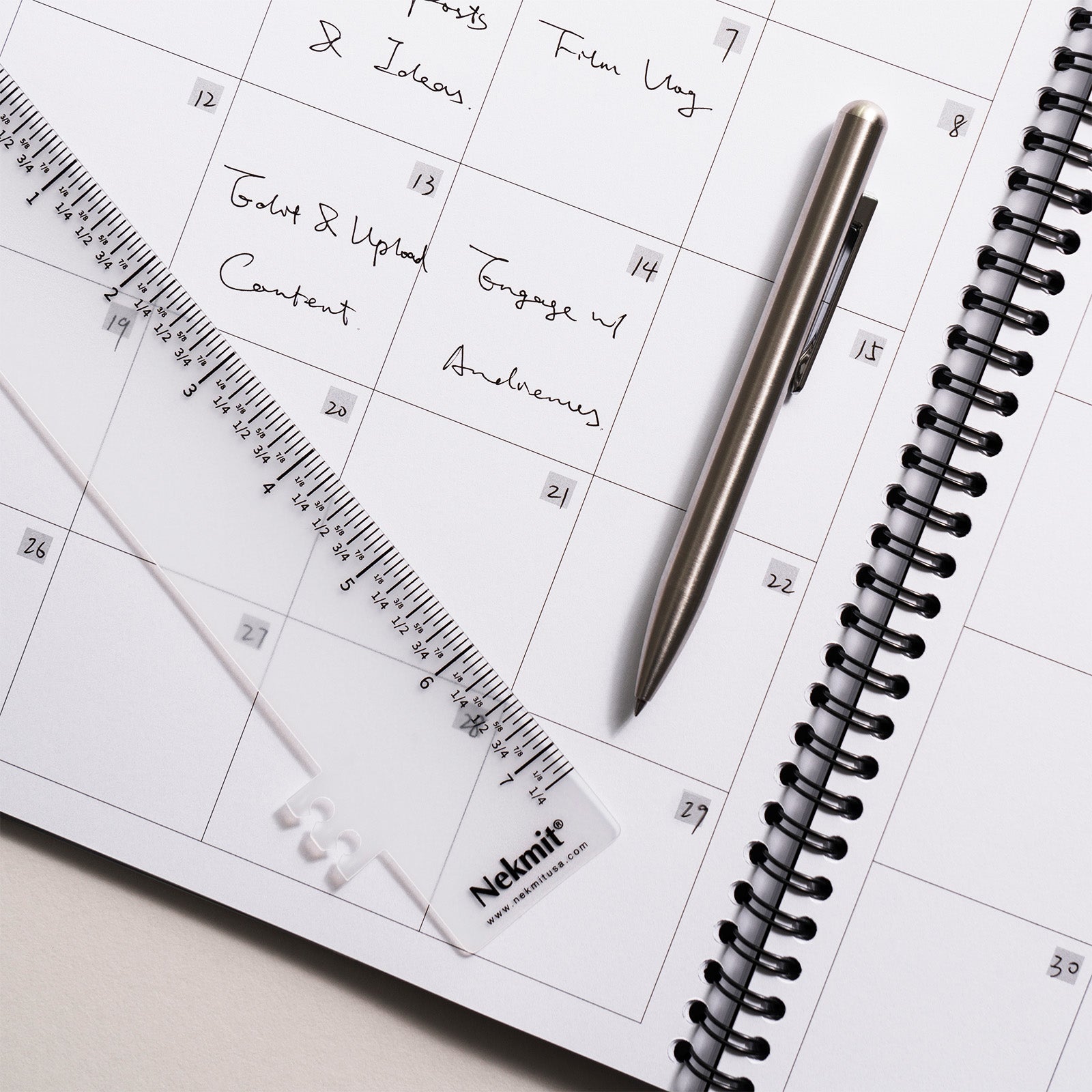 Calendar with pen and ruler on a desk, featuring the brand 'Nemitt'.