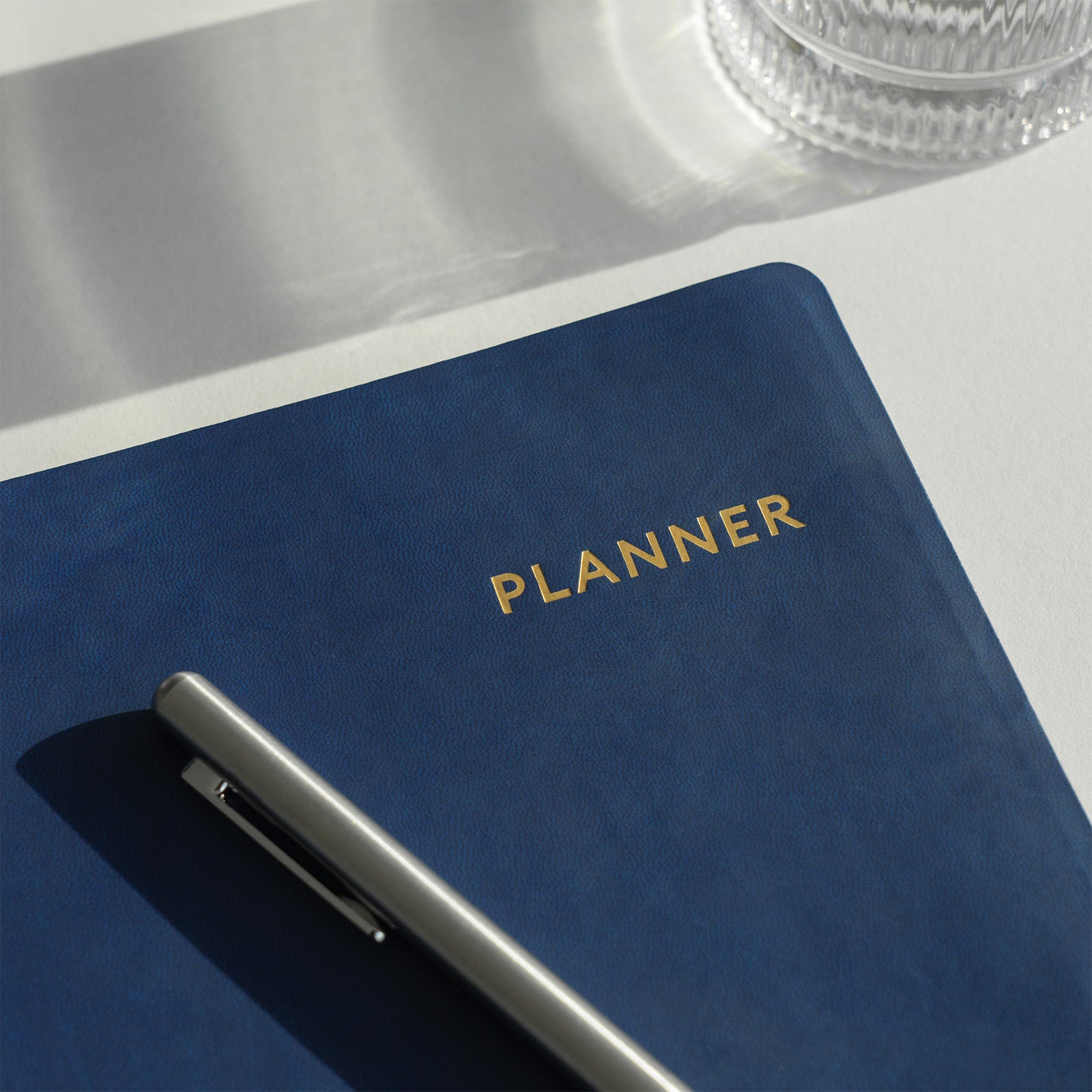 Blue planner with 'PLANNER' text on a white surface