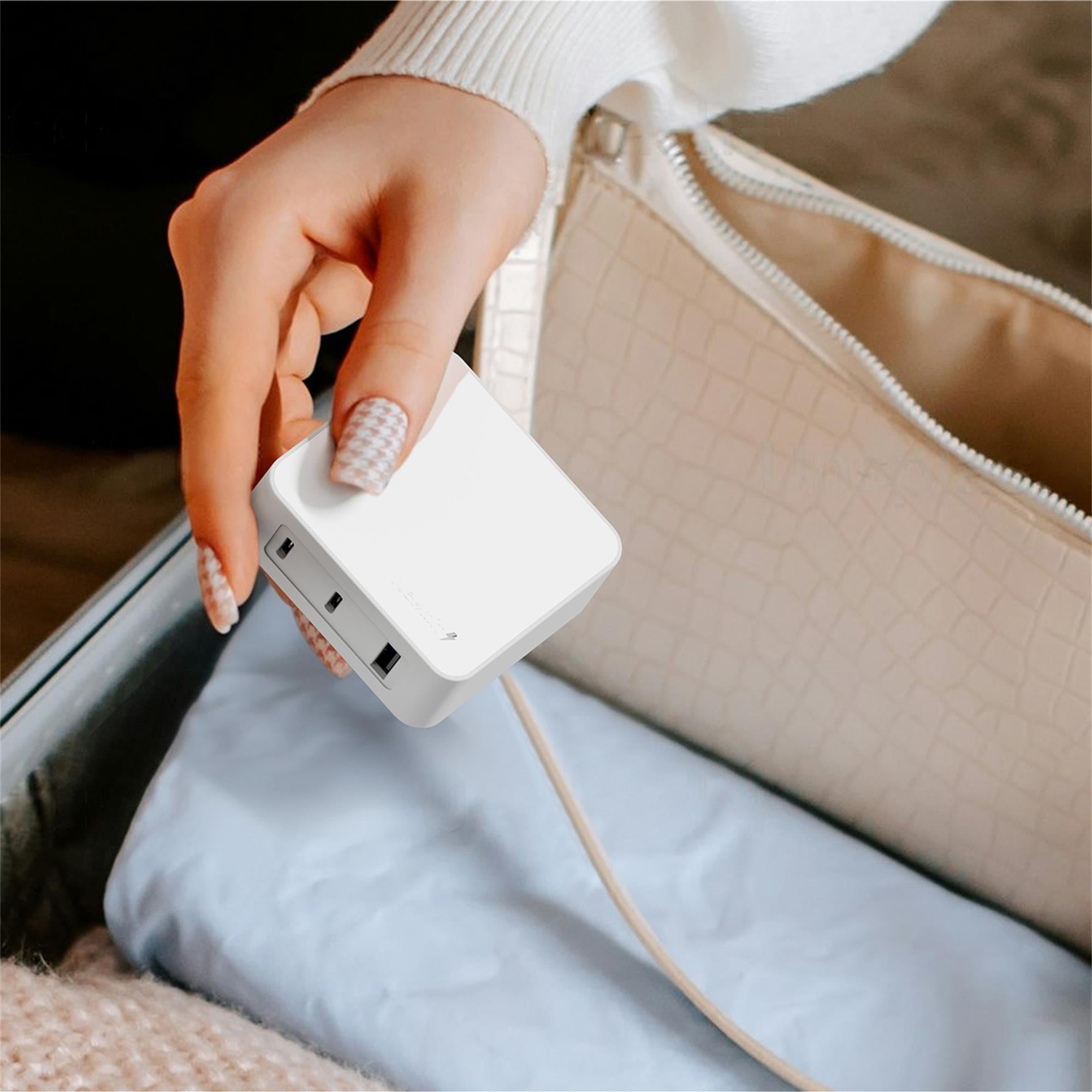 Hand plugging a white adapter into a device with a beige bag in the background