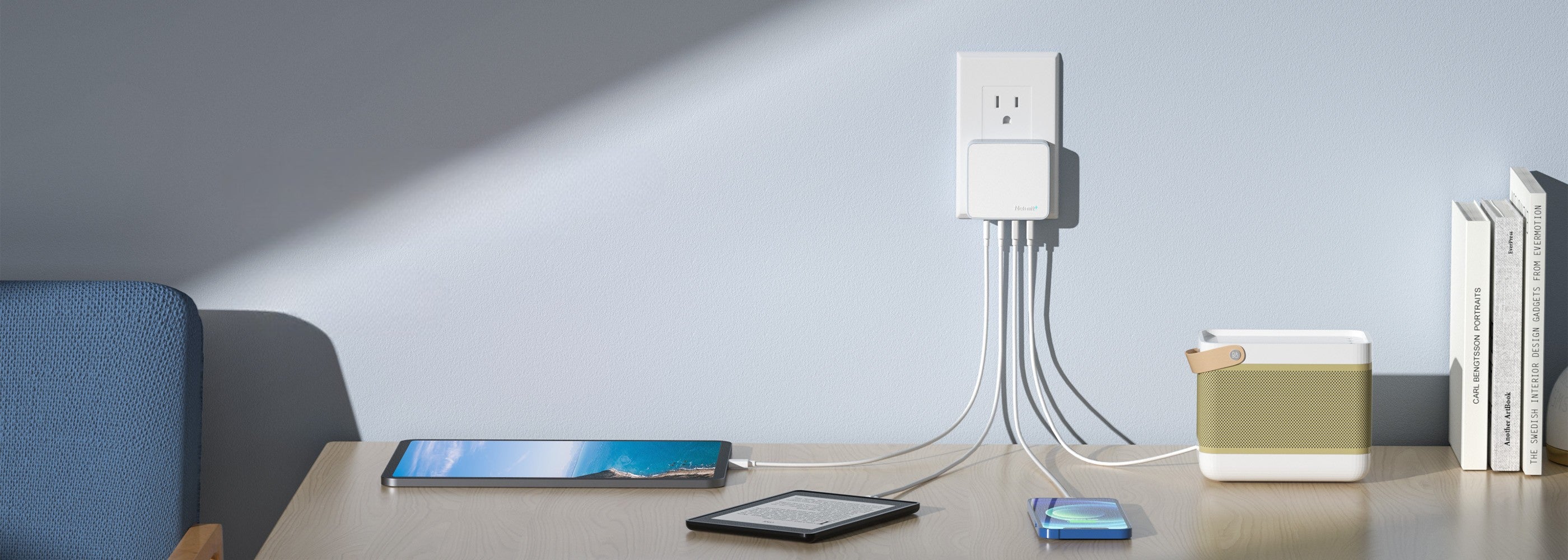 Smart home device with multiple cables on a table against a light gray wall.