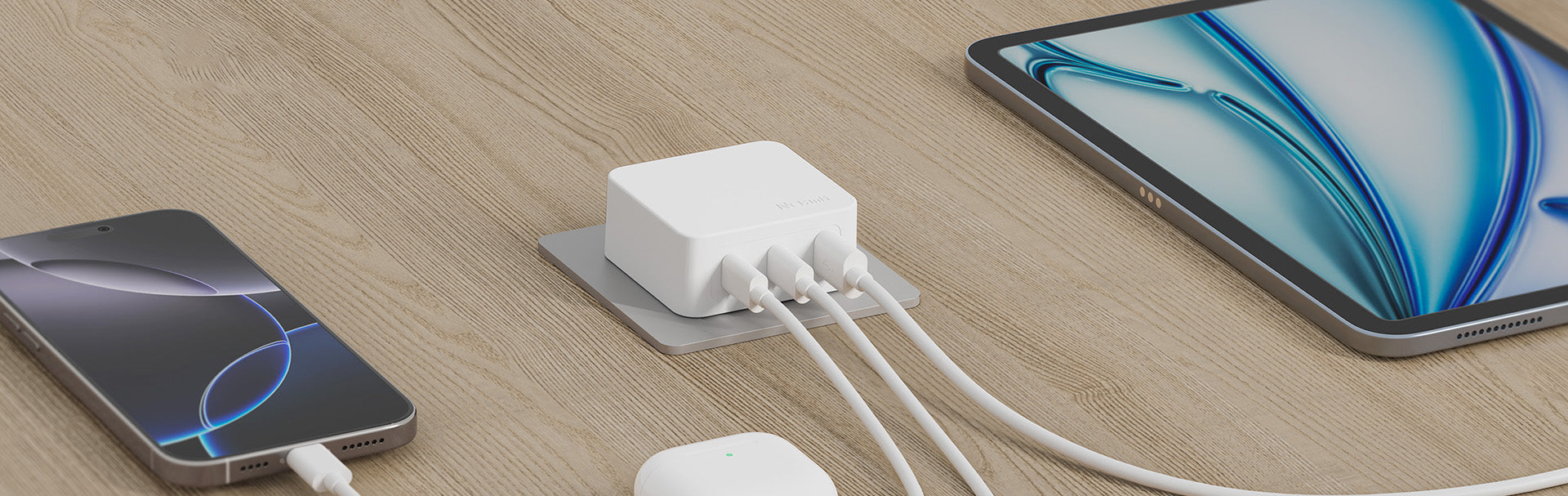 Two smartphones connected to a white USB hub on a wooden surface