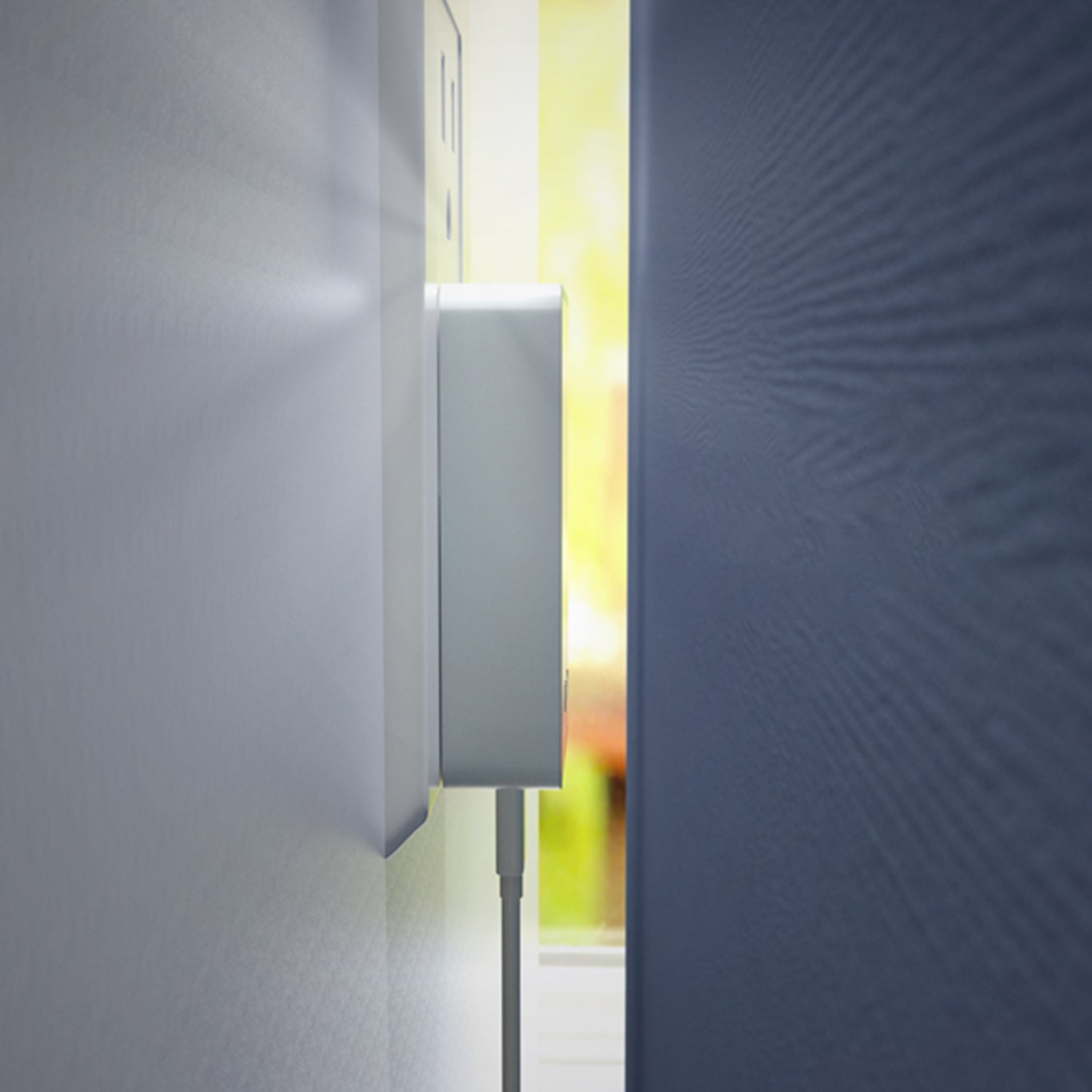 Close-up of a textured wall with a rectangular object attached, possibly a thermostat or sensor.