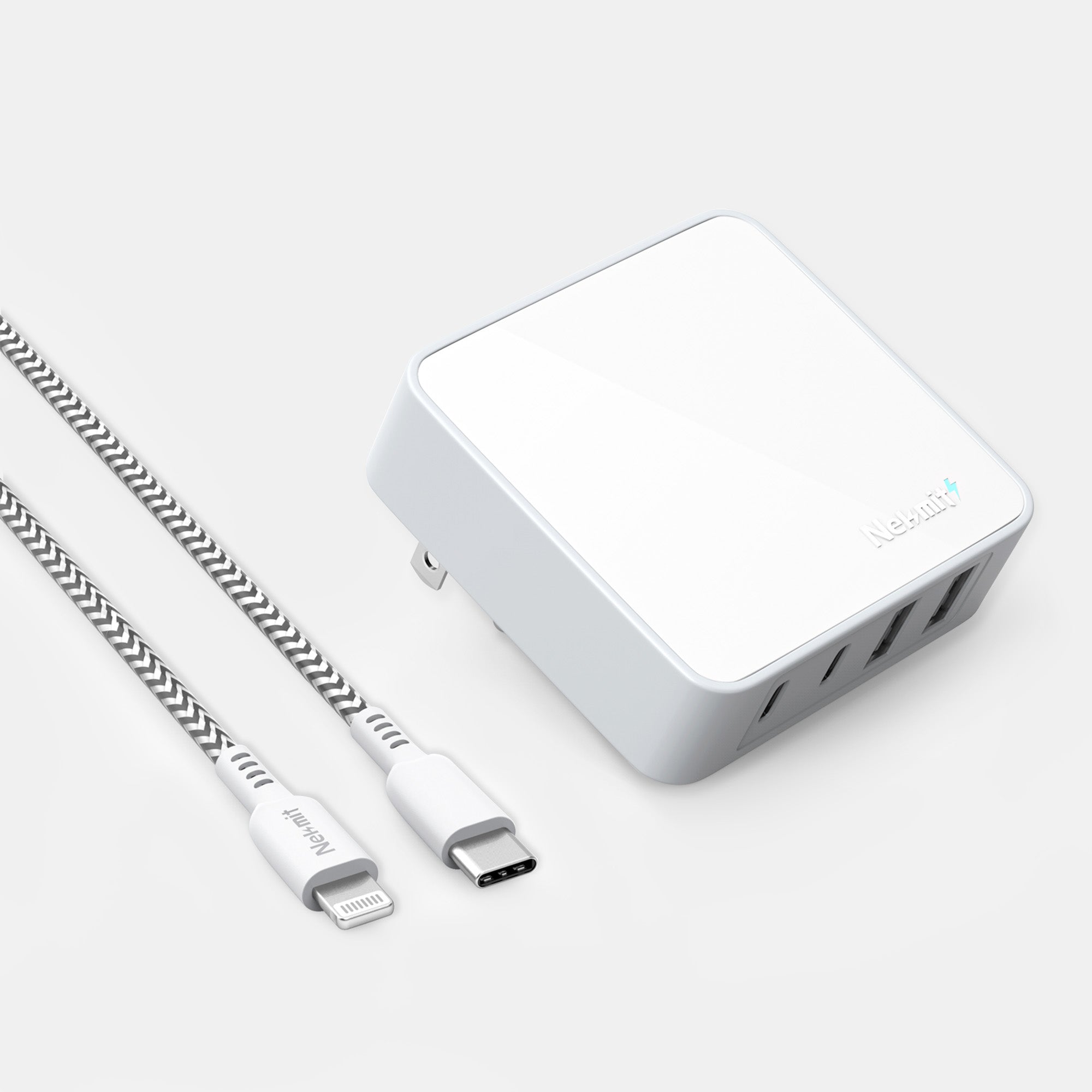 White power adapter with multiple ports and a USB-C cable on a light gray background