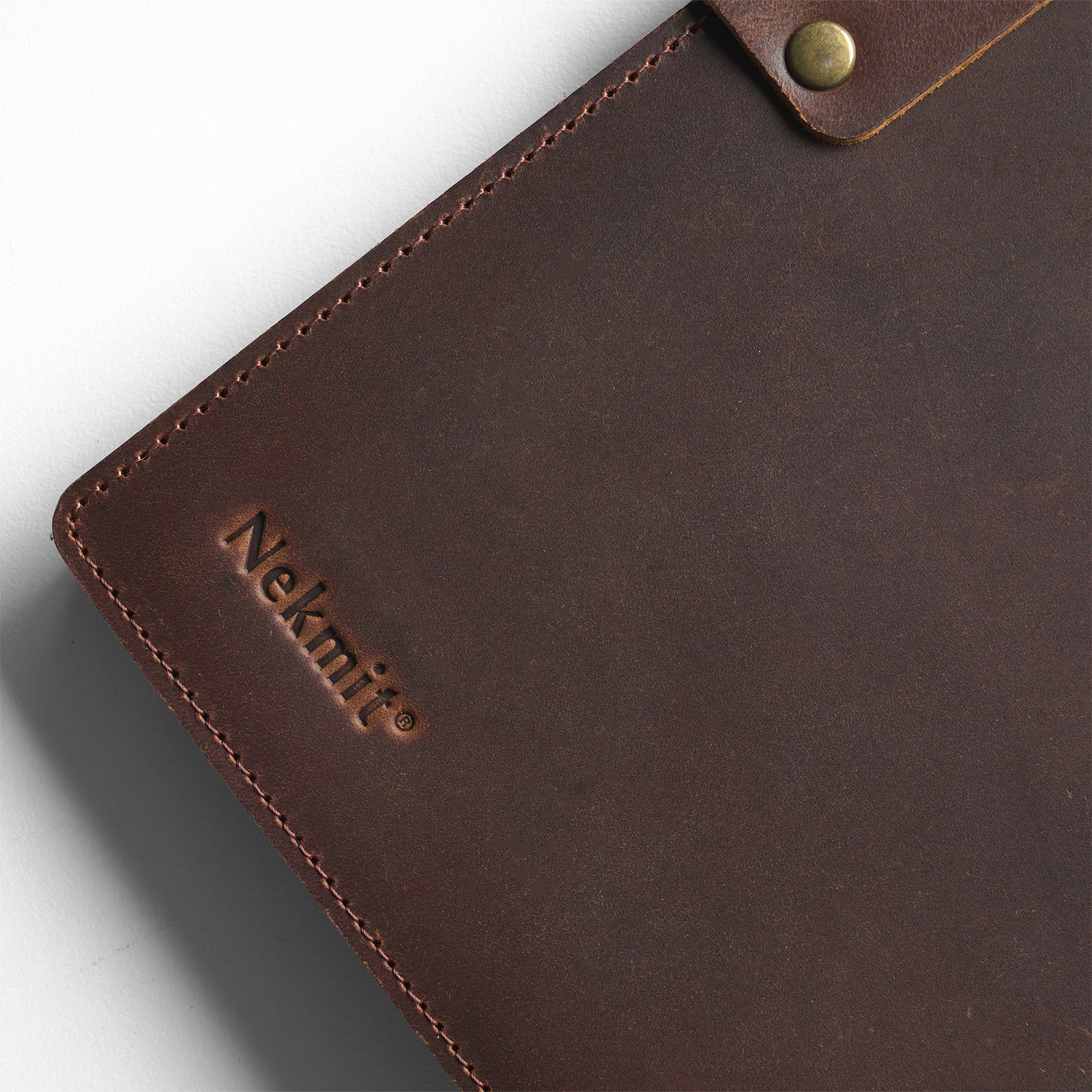 Brown leather case with 'Nekmit' branding on a light gray background