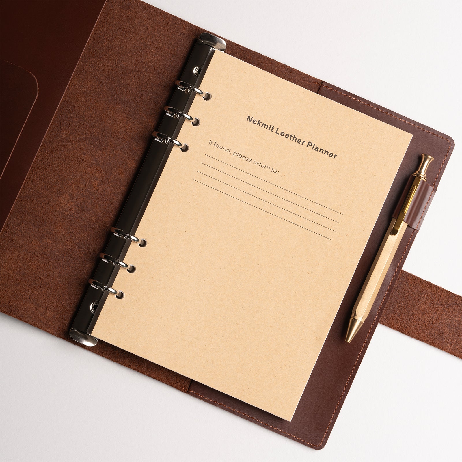 Brown leather planner with beige interior pages and a pen on a white background