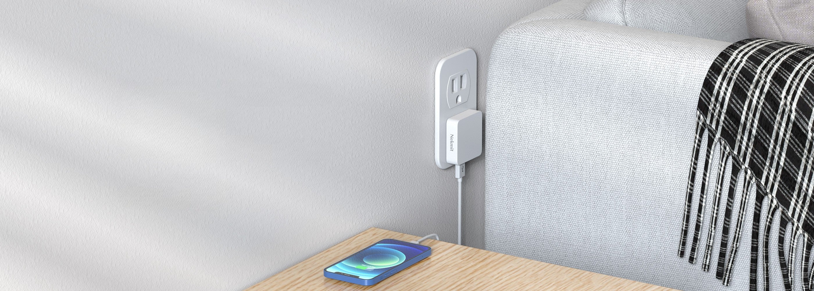 Phone on a wooden surface next to a power outlet with a white wall in the background
