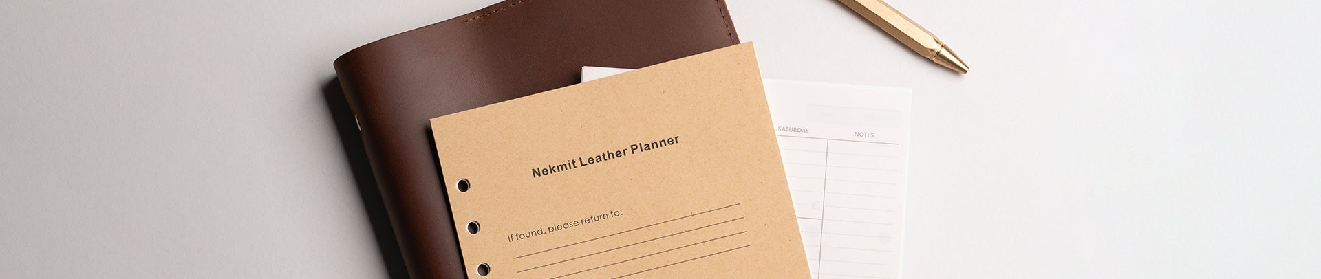 Brown leather-bound notebook with beige cover on a white surface