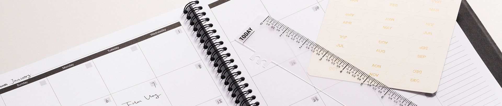 Open notebook with spiral binding and a ruler on a light surface