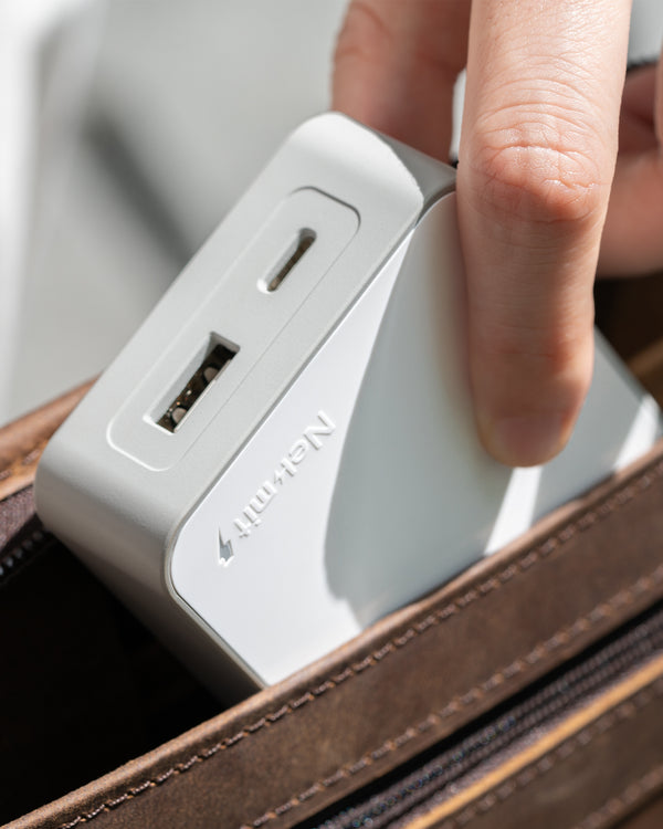 Person inserting a power adapter into a suitcase