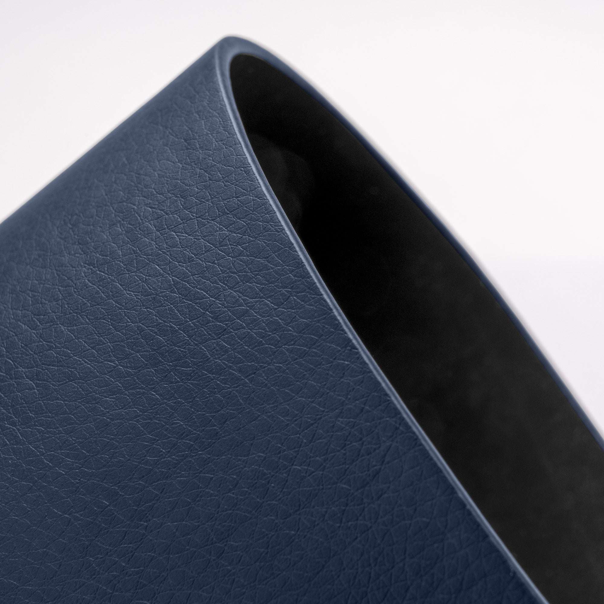 Close-up of a blue leather-bound book corner on a white background