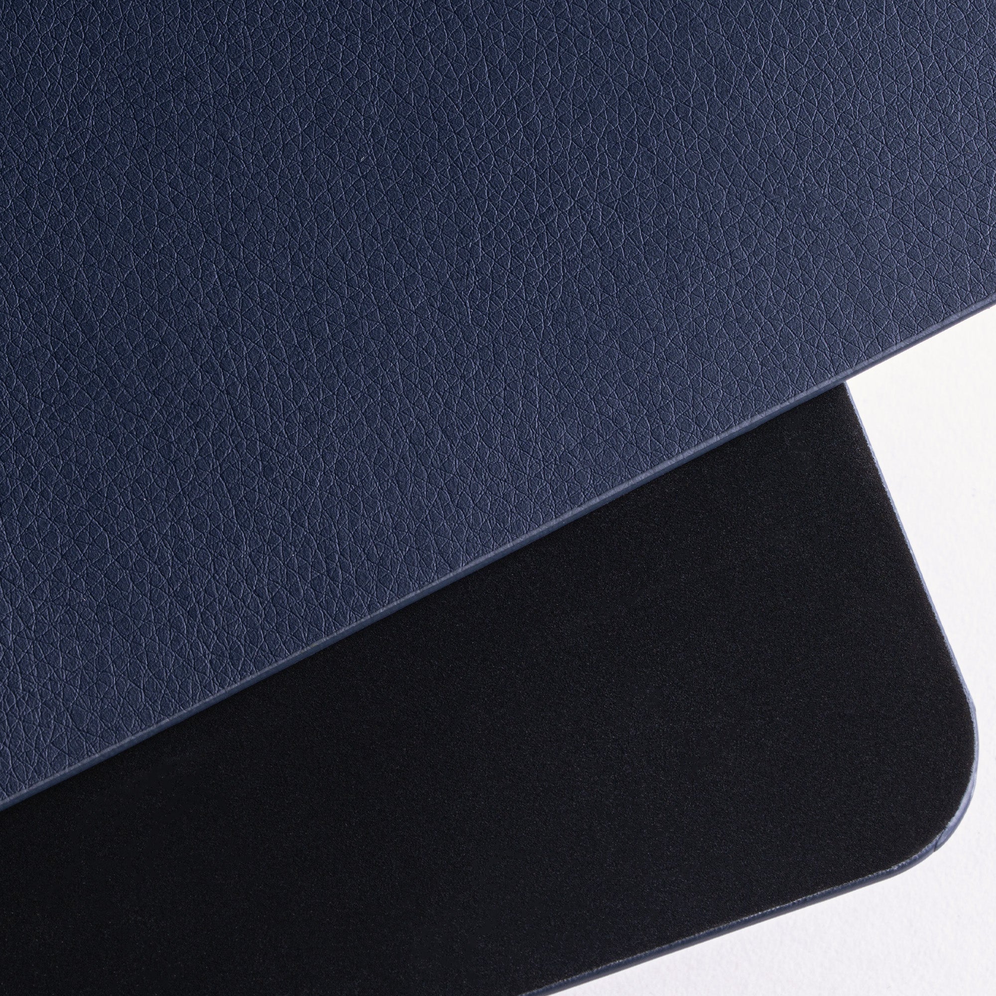 Close-up of a dark blue leather surface with a lighter blue border on a white background