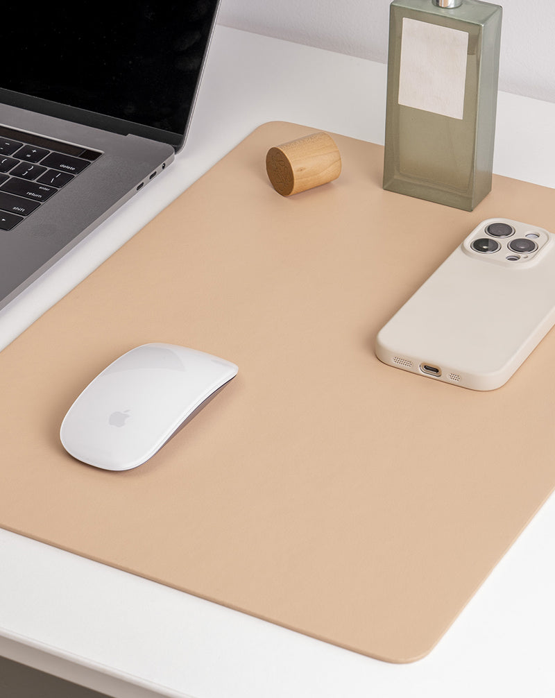 Beige desk mat with a laptop, mouse, and phone on a white surface