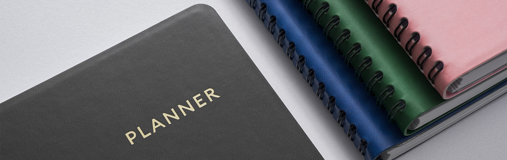 Black planner with 'PLANNER' text on a light gray background